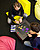 Zwei Studierende sitzen auf bunten Sitzgelegenheiten und spielen ein Computerspiel, das zwischen ihnen steht. 