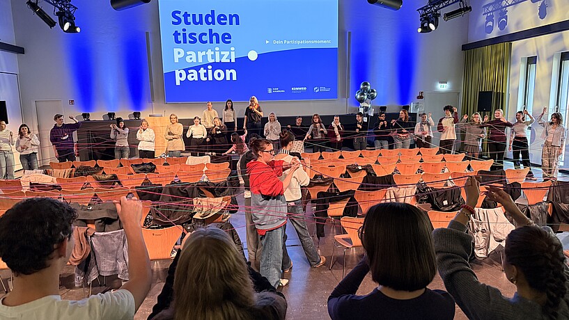 Studierende spannen ein Netz aus Garn 