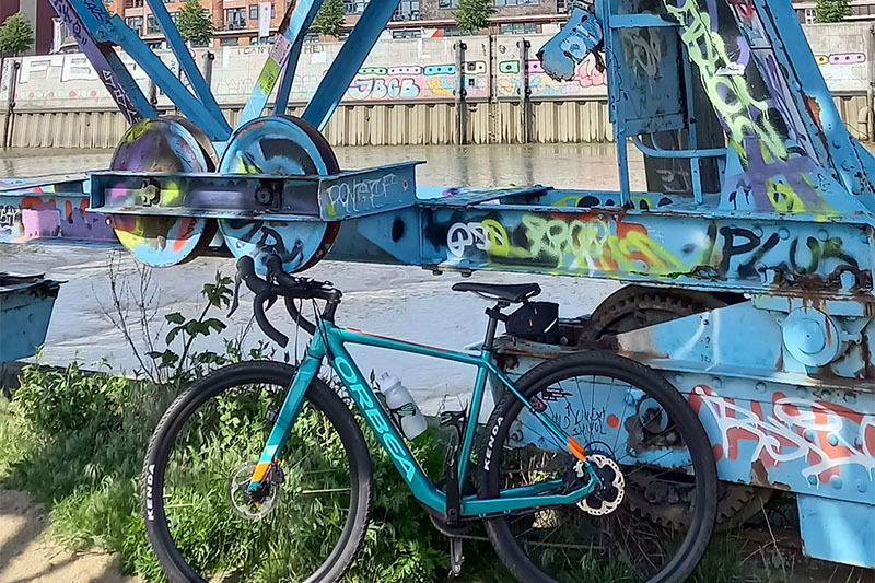 
                Rennrad vor altem Hafenkransockel, auf dem Grafittis sind
            