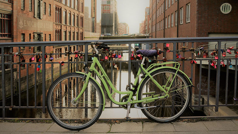 Grünes Damenrad steht auf einer Brücke in der Hamburger Speicherstada
