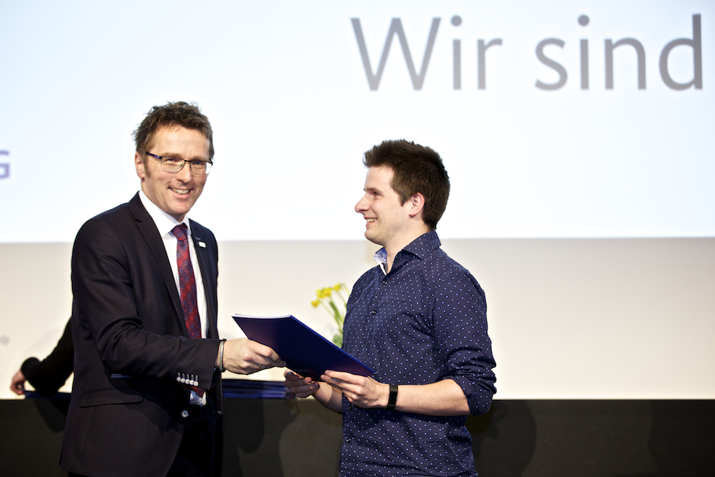 Hochschulpräsident der HAW Hamburg, Prof. Dr. Micha Teuscher überreicht eine Stipendienurkunde