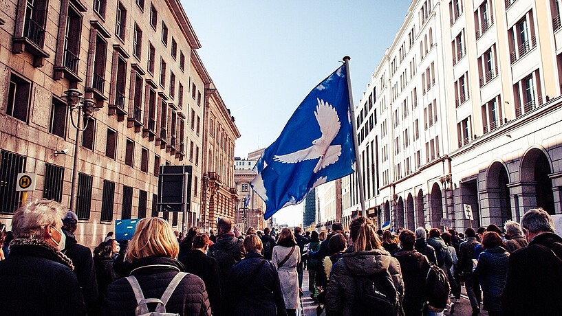 Demonstration für den Frieden mit einer Flagge mit einer Friedenstaube