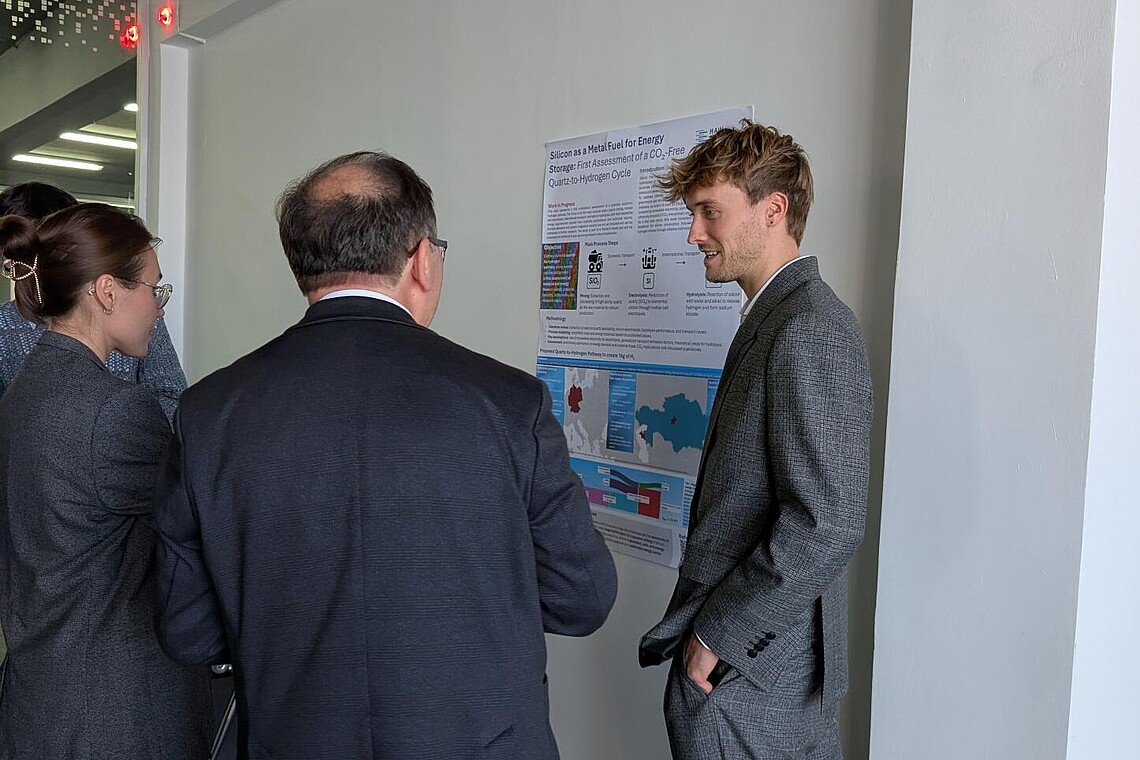 Drei Personen, davon mindestens ein Student unterhalten sich.