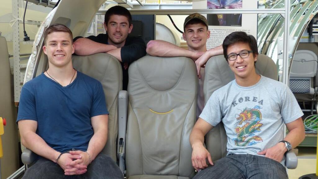 Four males students sitting in a cabin mock-up