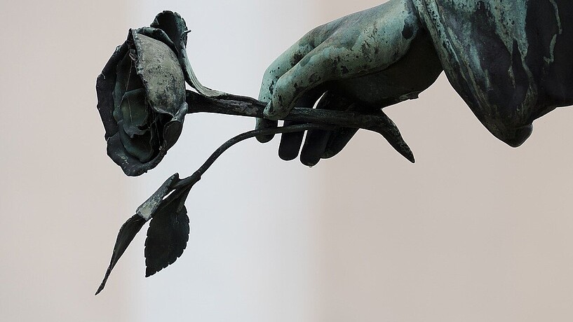 Arm einer Skulptur mit einer Rose in der Hans