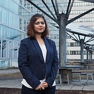 Female student standing in front of solar pabels at a university campus