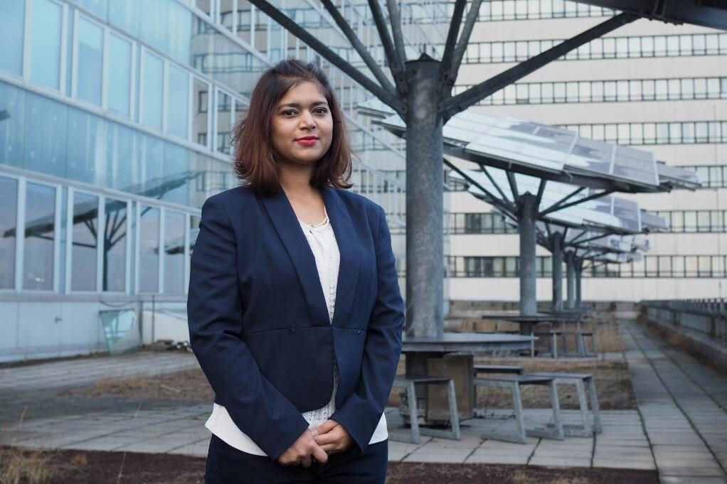 Female student standing in front of solar pabels at a university campus