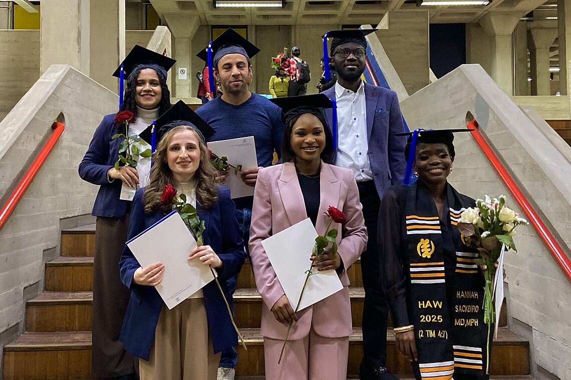 Die  Absolvent:innen des Master of Public Health stehen auf einer Treppe, damit ein Gruppenfoto gemacht werden kann.