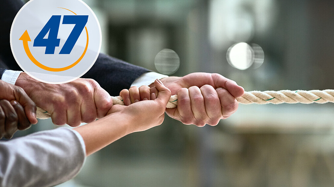 Vier Hände ziehen wie beim Tauziehen an einem Ende eines Seils.