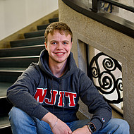 
                                Male student sitting on steps
                            