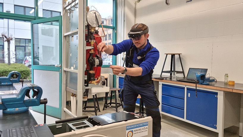 Hier sieht man einen Azubi, der mit Hilfe einer AR-Brille eine Maschine bedient