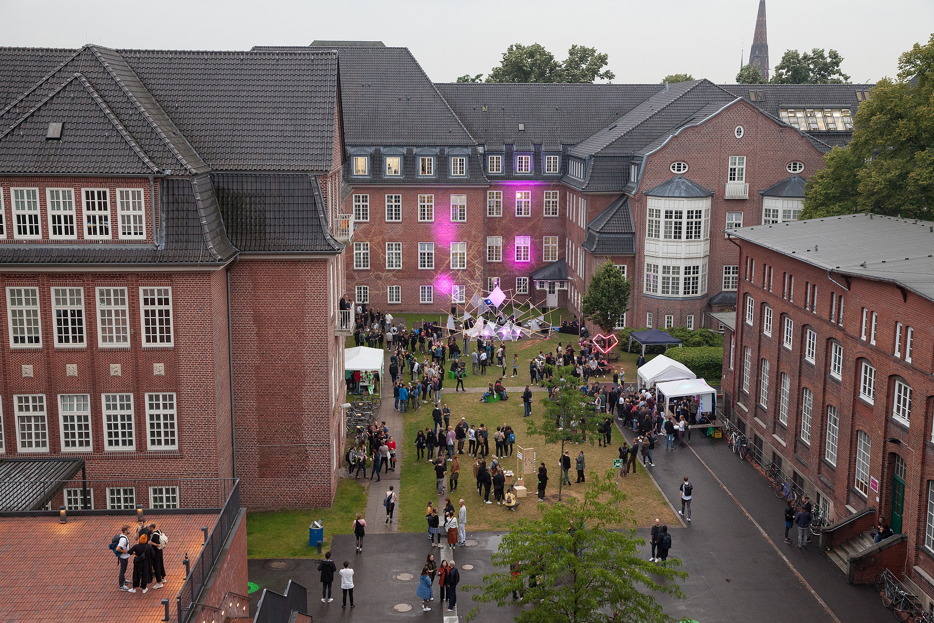 People in courtyard of Hamburg Art and Media Campus during 2019 campus tour...