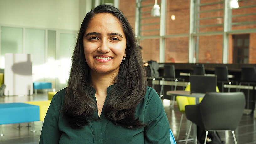 Female person from India sitting in a university foyer