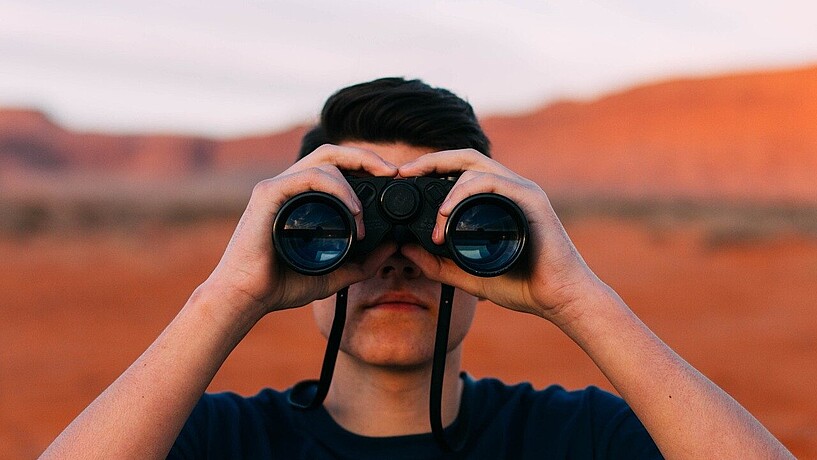 Man looking through a pair of binoculars