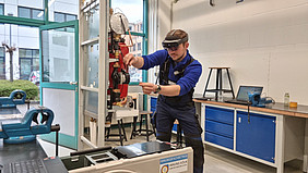Hier sieht man einen Azubi, der mit Hilfe einer AR-Brille eine Maschine bedient
