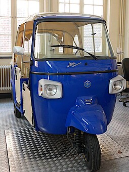 
                Eine blaue, elektrische Rikscha steht an der HAW Hamburg.
            