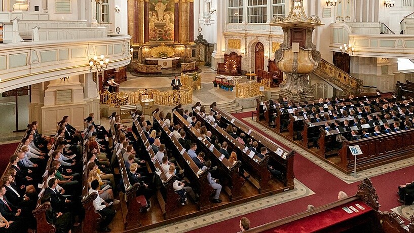 Blick von oben auf die Absolvent*innen in der Kirche Sankt Michaelis