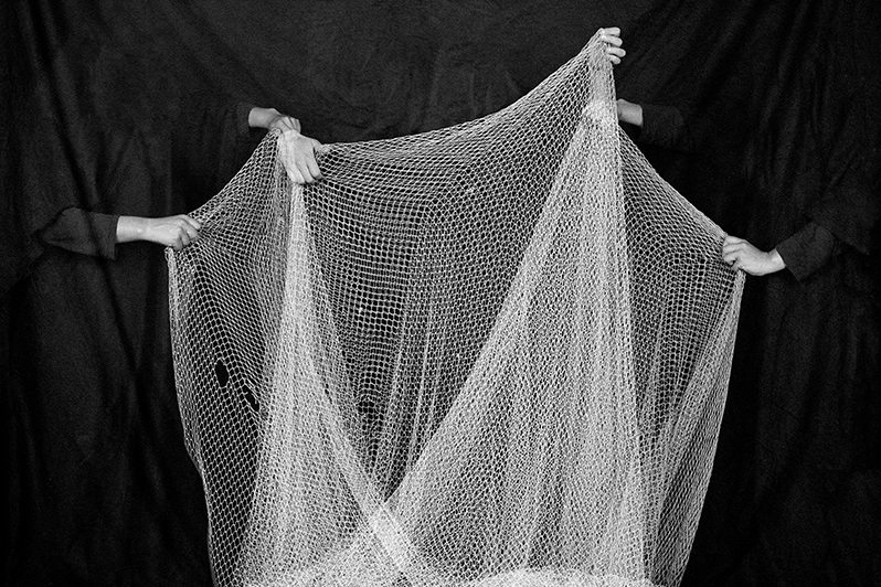 Aufgespanntes weißes Netz vor dunklem Hintergrund