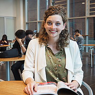 Sara Stemberger - exchange student Female student sitting with a book in a university lobby