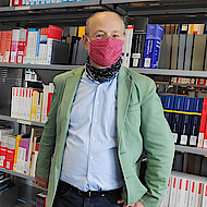 Claudia Wessendorf (l.) und Holger Wendt (r.) stehen vor einem Bücherregal in einer der Bibliotheken der HAW Hamburg