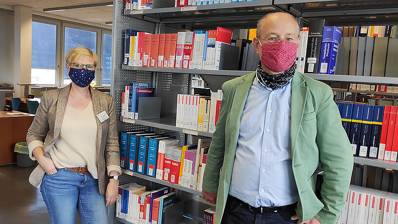 Claudia Wessendorf (l.) und Holger Wendt (r.) stehen vor einem Bücherregal in einer der Bibliotheken der HAW Hamburg