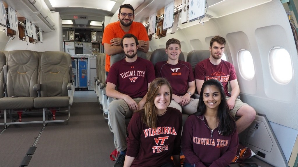 Male and female students sitting in an aircraft cabin