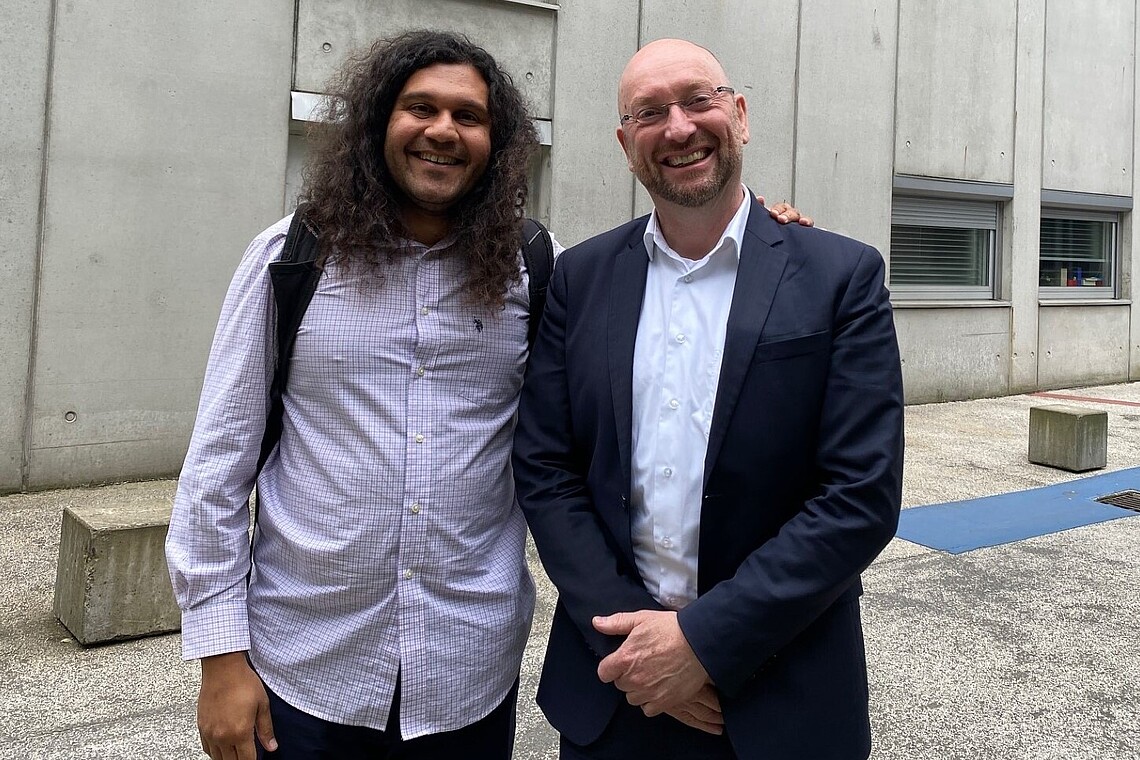 Two professors in front of a university building