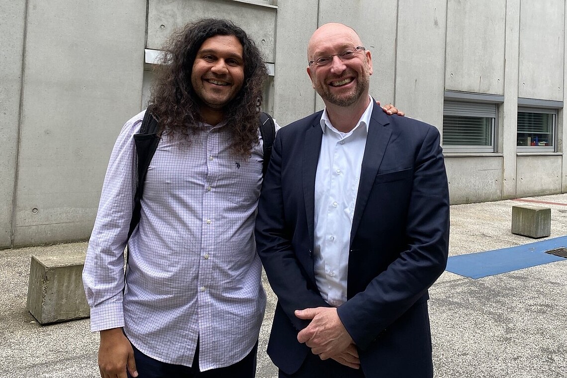 Two professors in front of a university building