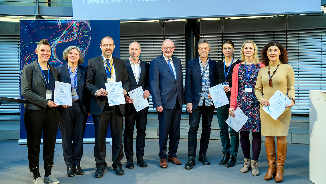 Das Bild zeigt die Vertreter*innen der ausgezeichneten Hochschulen gemeinsam mit Michael Meister, dem parlamentarischen Staatssekretär beim Bundesministerin für Bildung und Forschung.
