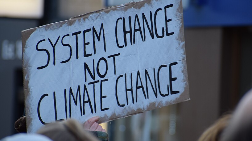 Plakat auf einer Demonstration gegen den Klimawandel "System change noch Climate Change"
