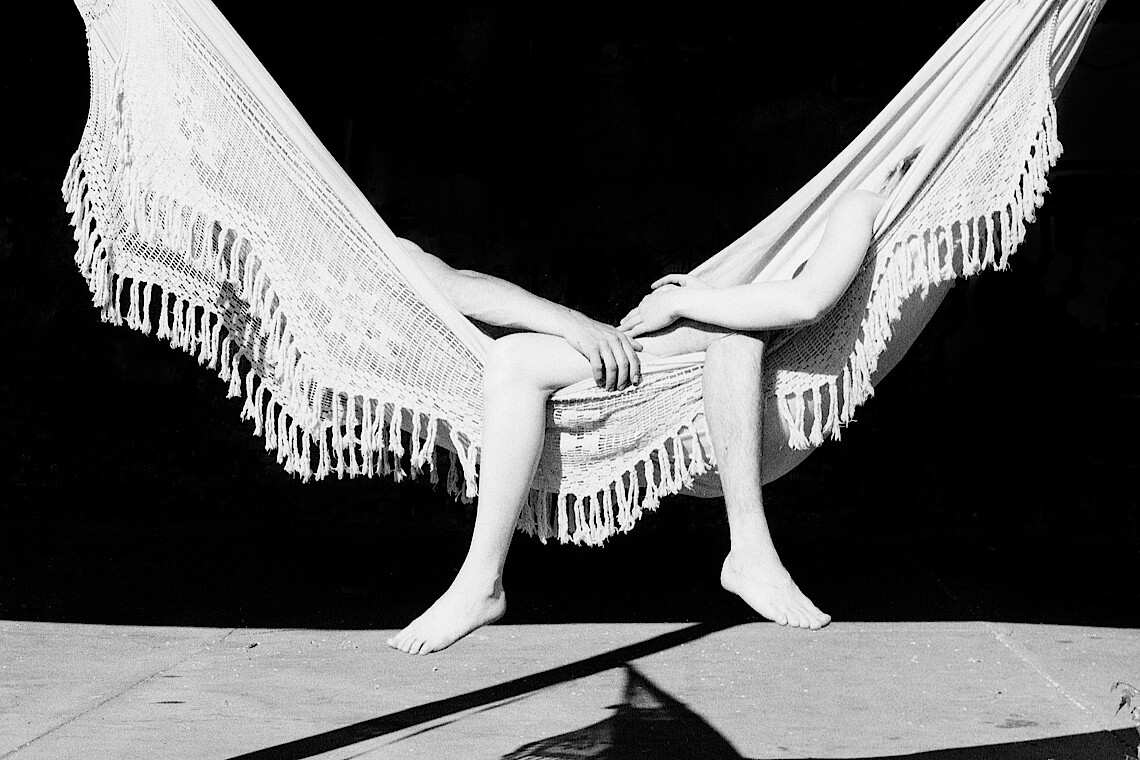 Fotokunstwerk mit Füßen und Armen, die aus einer Hängematte gucken