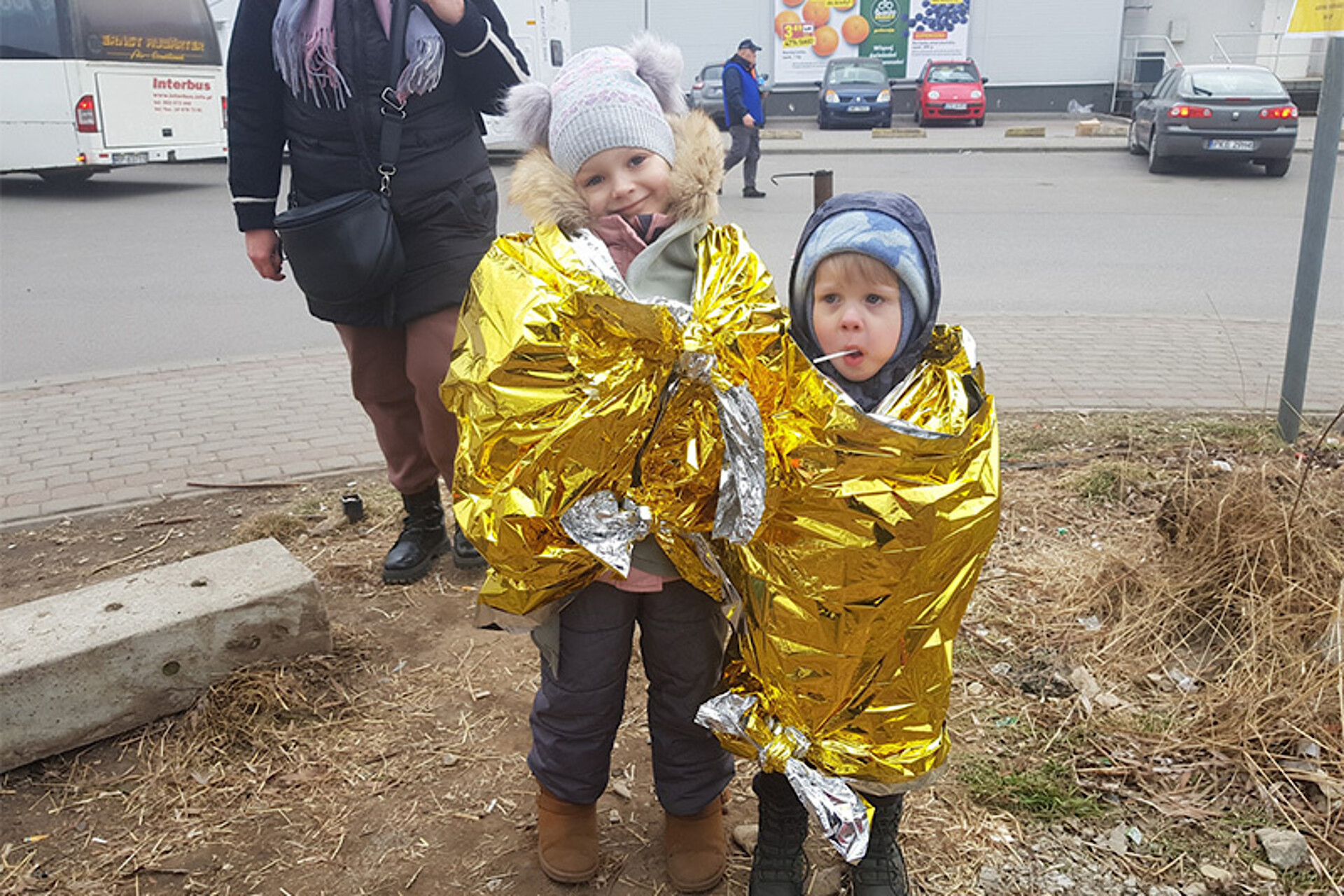 
                                                Zwei kleine Kinder, eingehüllt in Wärmedecken 
                                            
