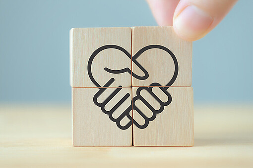 
                Zwei Hände greifen ineinander und formen ein Herz
            