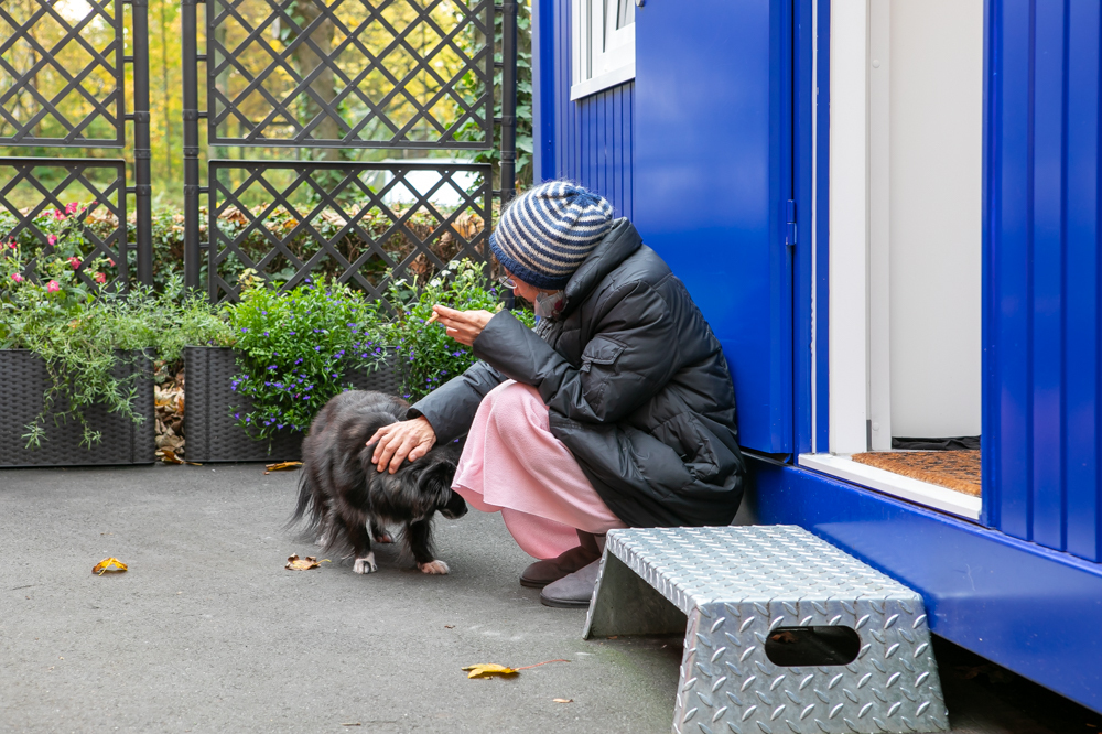 Eine Frau lebt mit ihrem Hund in den Wohncontainern auf dem Campus.