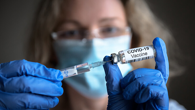 A woman prepares a needle for a coronavirus vaccination.