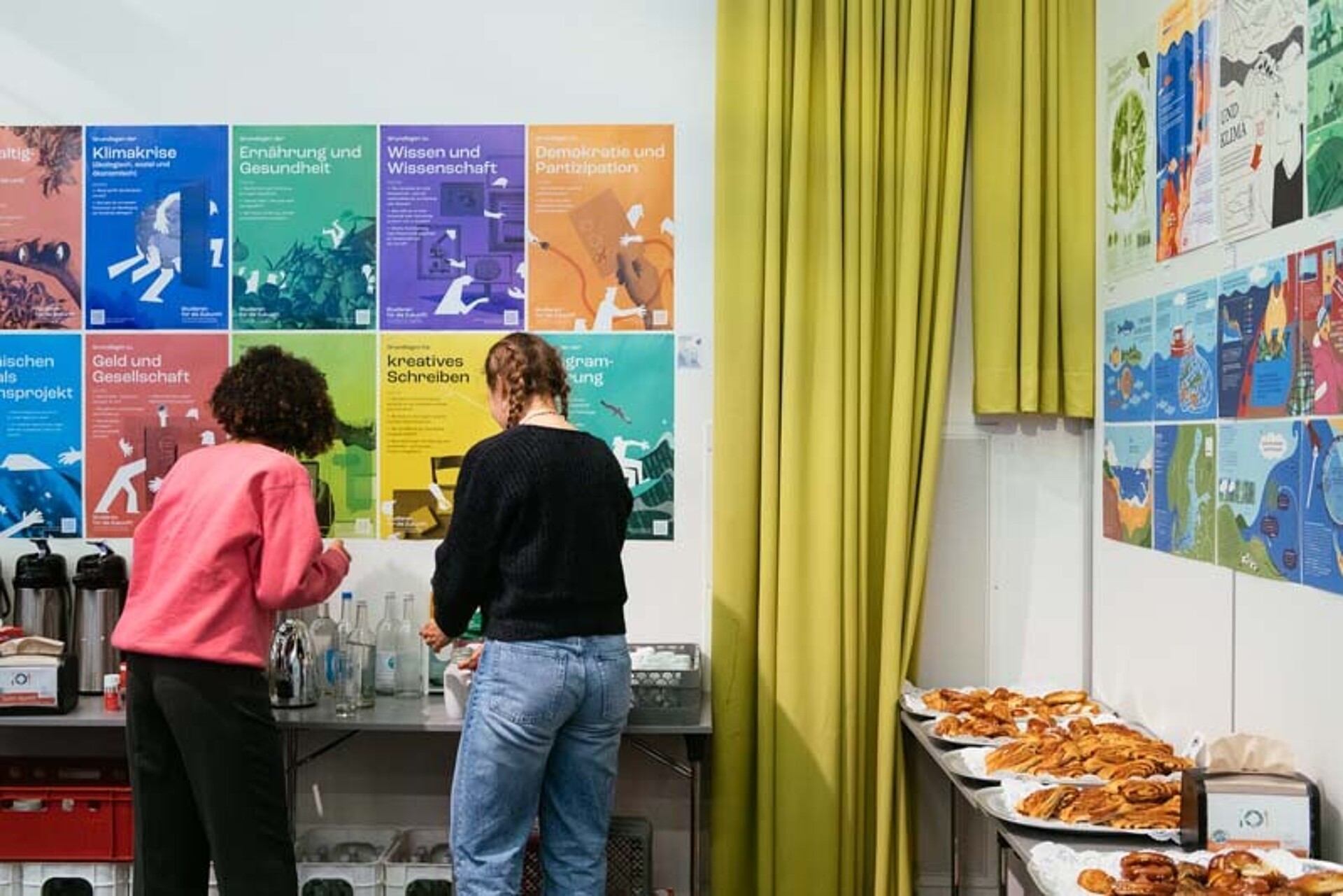 
                                                Am Catering stehen zwei Teilnehmende
                                            