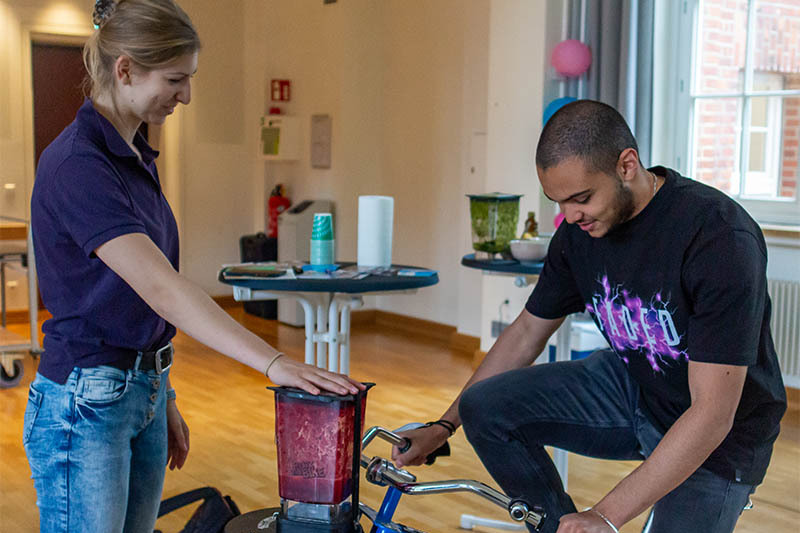 ein Student auf einem Rad erzeugt mit dem Fahren Energie für einen Mixer