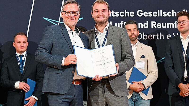 Masterstudent Tom Ziegner (rechts) erhält den Nachwuchspreise der Deutschen Gesellschaft für Luft- und Raumfahrt aus der Hand von Roland Gerhards, dem Präsidenten der DGLR.