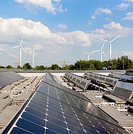 Ausblick PV-Anlagen und Windpark Ausblick PV-Anlagen auf Dach und fünf Windräder im Hintergrund