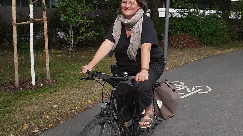 Andrea Kupke auf einem Rad auf einem Radweg im Park