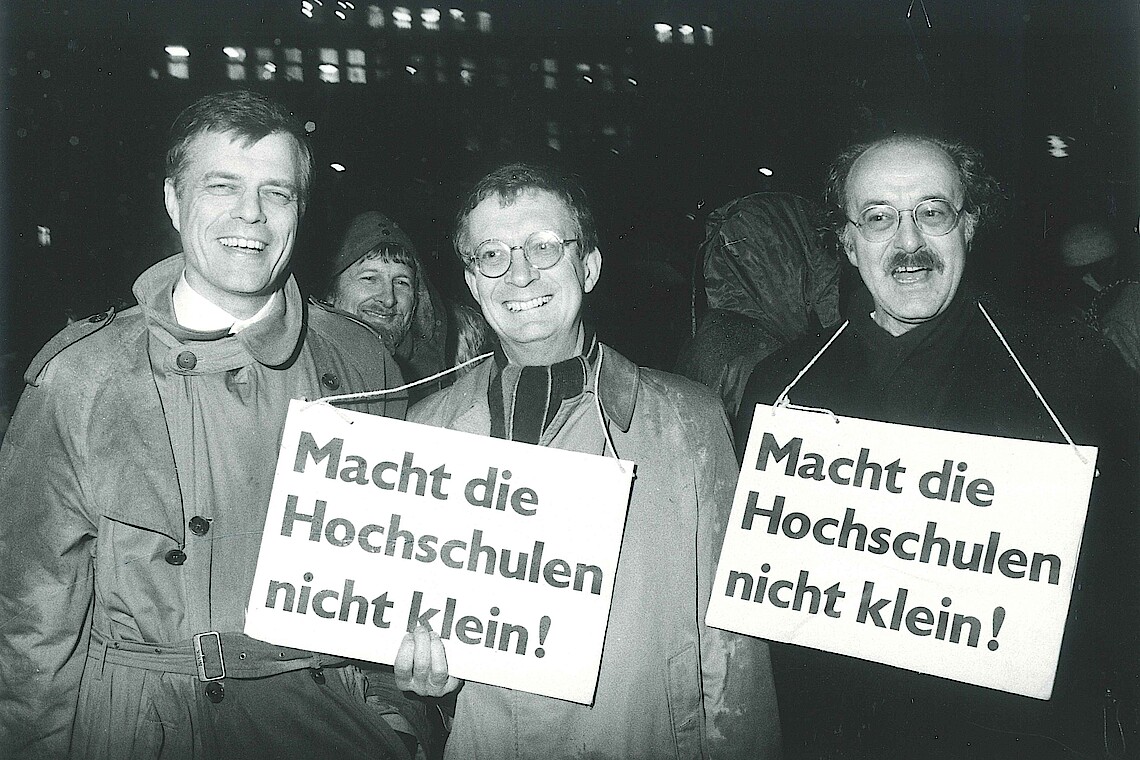 Drei Männer schwarz-weiß Fotografie mit Schildern auf denen steht "Macht die Hochschulen nicht klein!"