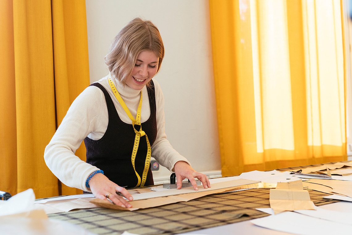 Studentin am Tisch beim Schneidern im Labor Fertigungstechnik