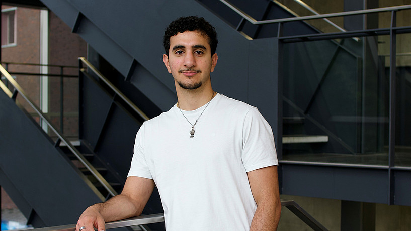 Male student standing in university building
