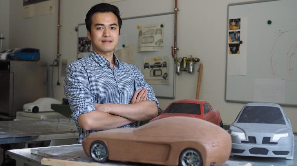 Male student posing with model cars