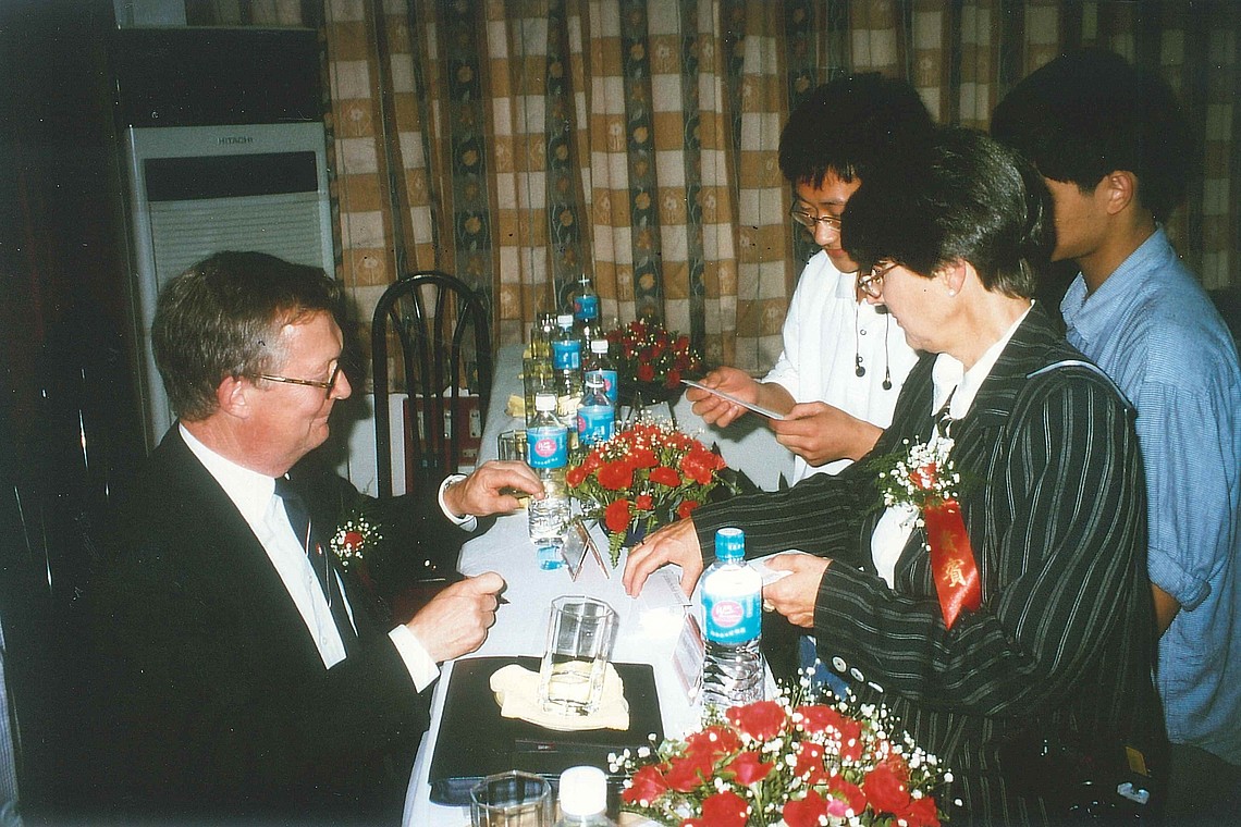 1998 - FH-Präsident Prof. Dr. Rolf Dalheimer unterschreibt Lesezeichen der Hochschule und schenkt sie chinesischen Studierenden.