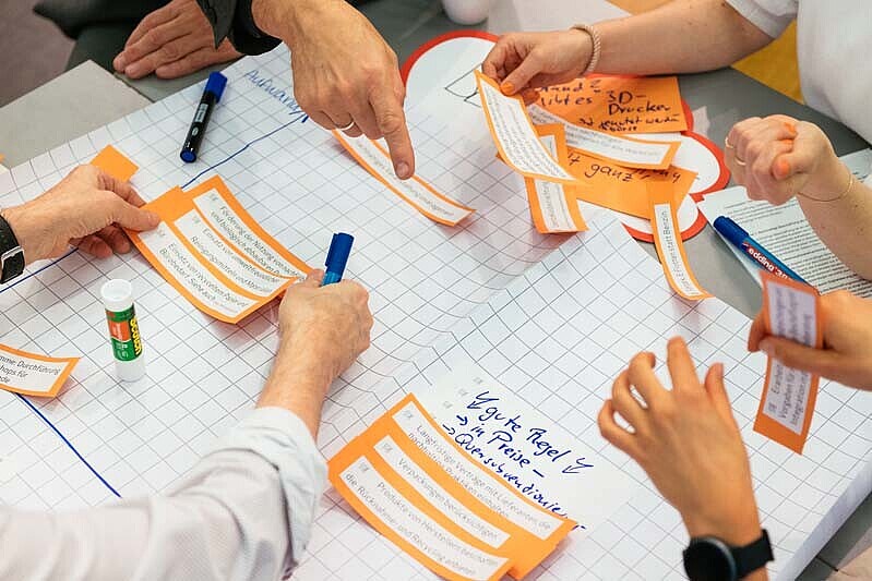 Ein Arbeitstisch zum zkh-Projekt mit Händen wird gezeigt