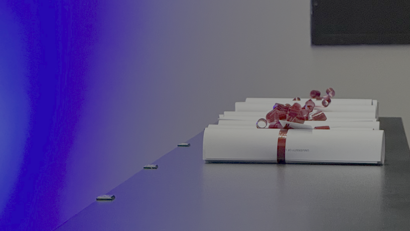 Absolvent*innenfeier LS Abschlusszeugnisse liegen gerollt, mit Schleifen auf einer Fläche