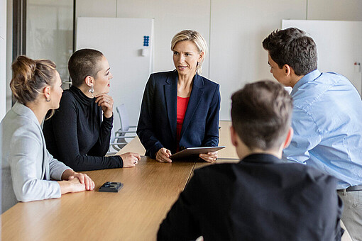 Grundlagen der Personalführung in sozialen Einrichtungen
Fünf Personen sitzen an einem Tisch und reden miteinander.