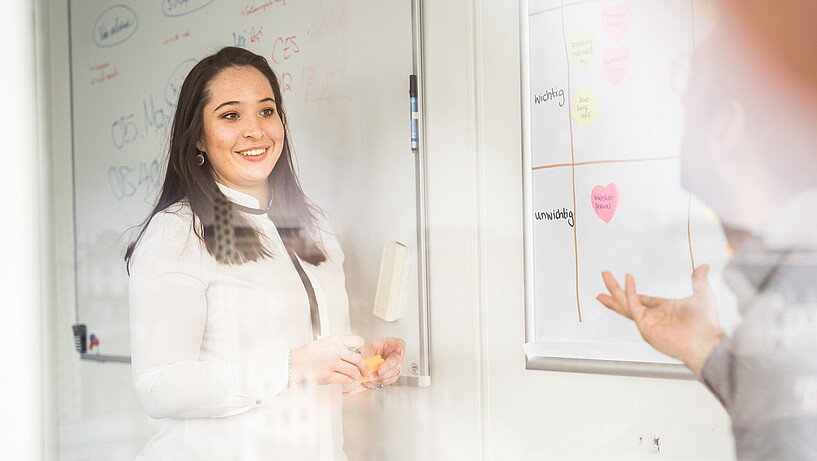 Eine Frau eines Gründungsteams steht symbolisch in den Räumen des CareerService.