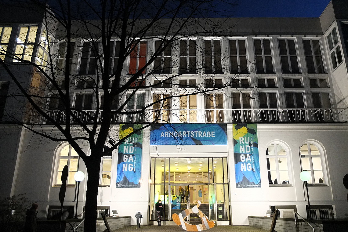 Armgartstraße building lit up at night with banner for the 2019 tour